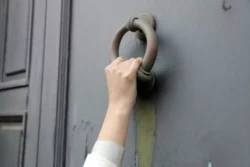 close de uma pessoa batendo na porta com uma velha aldrava 700x467 1